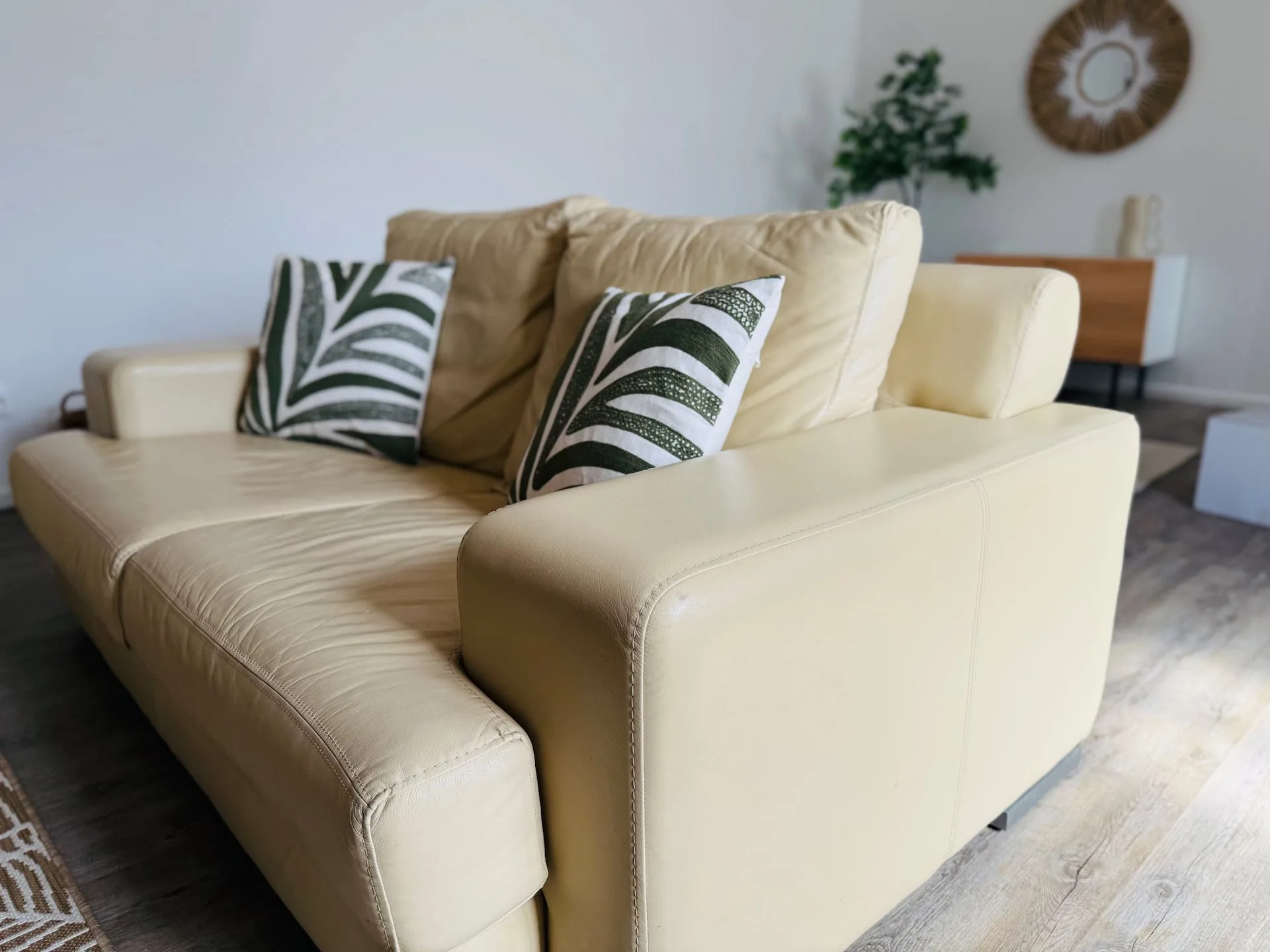 Sofá com almofadas botânicas e rattan