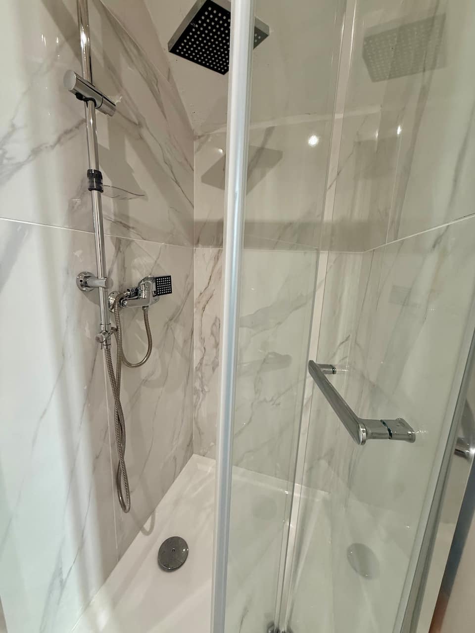 Banheira com chuveiro rain shower preto e pedra natural